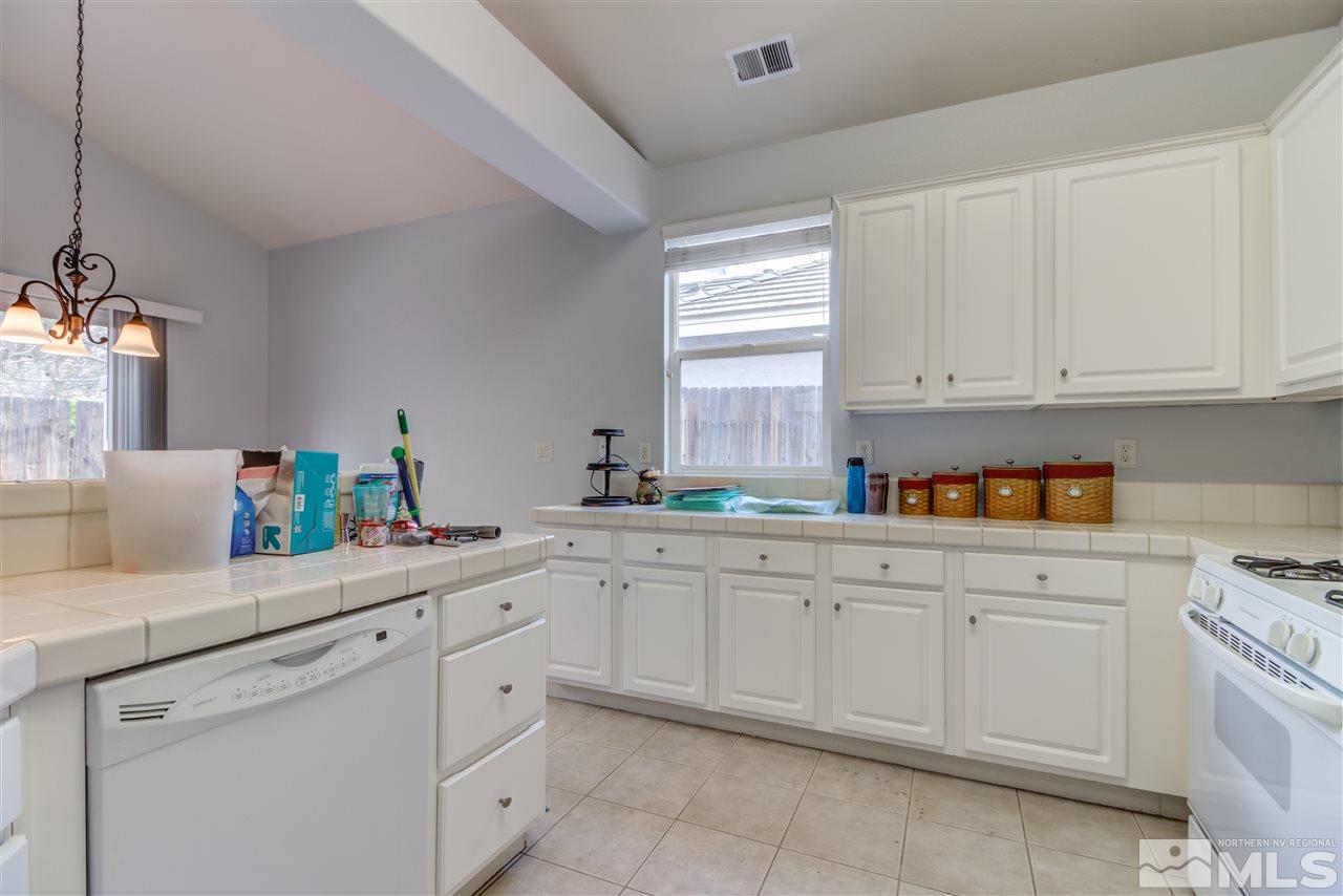 9724 Ripple Way Reno, NV 89521 - Photo 9 of 19 a kitchen with white cabinets and white appliances
