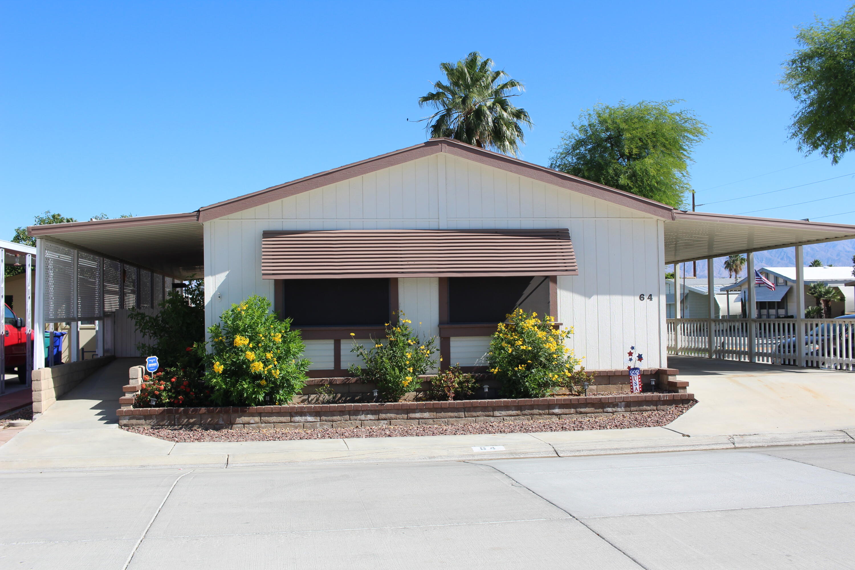 46618 Madison Street, Unit 64 Indio, CA 92201 - Photo 1 of 26 a front view of a house with plants
