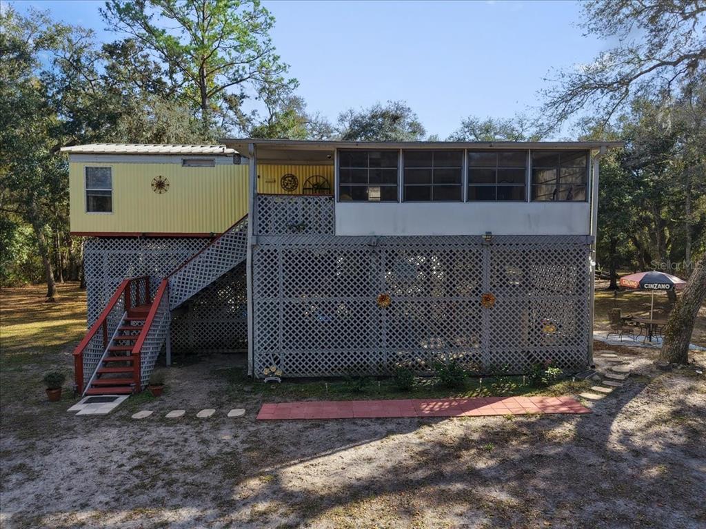 a view of a house with a yard and a large tree