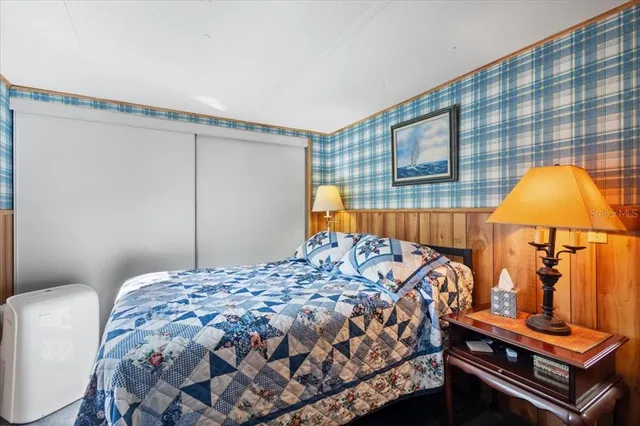 a bedroom with a bed and dresser with mirror