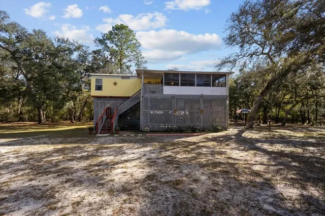 a view of a large white building with a big yard