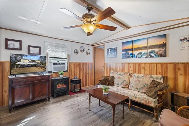 a living room with stainless steel appliances granite countertop furniture a couch and a bookshelf