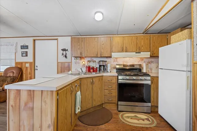 a kitchen with stainless steel appliances a stove a refrigerator and a sink