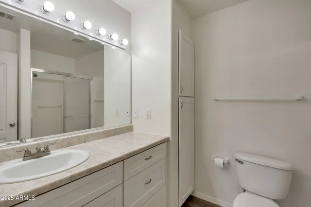 a bathroom with a granite countertop sink a toilet and a mirror