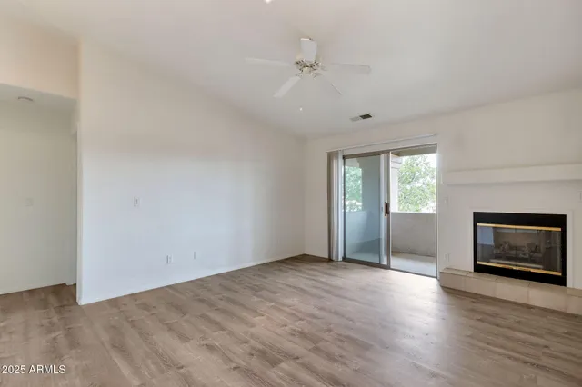 an empty room with windows and a fireplace