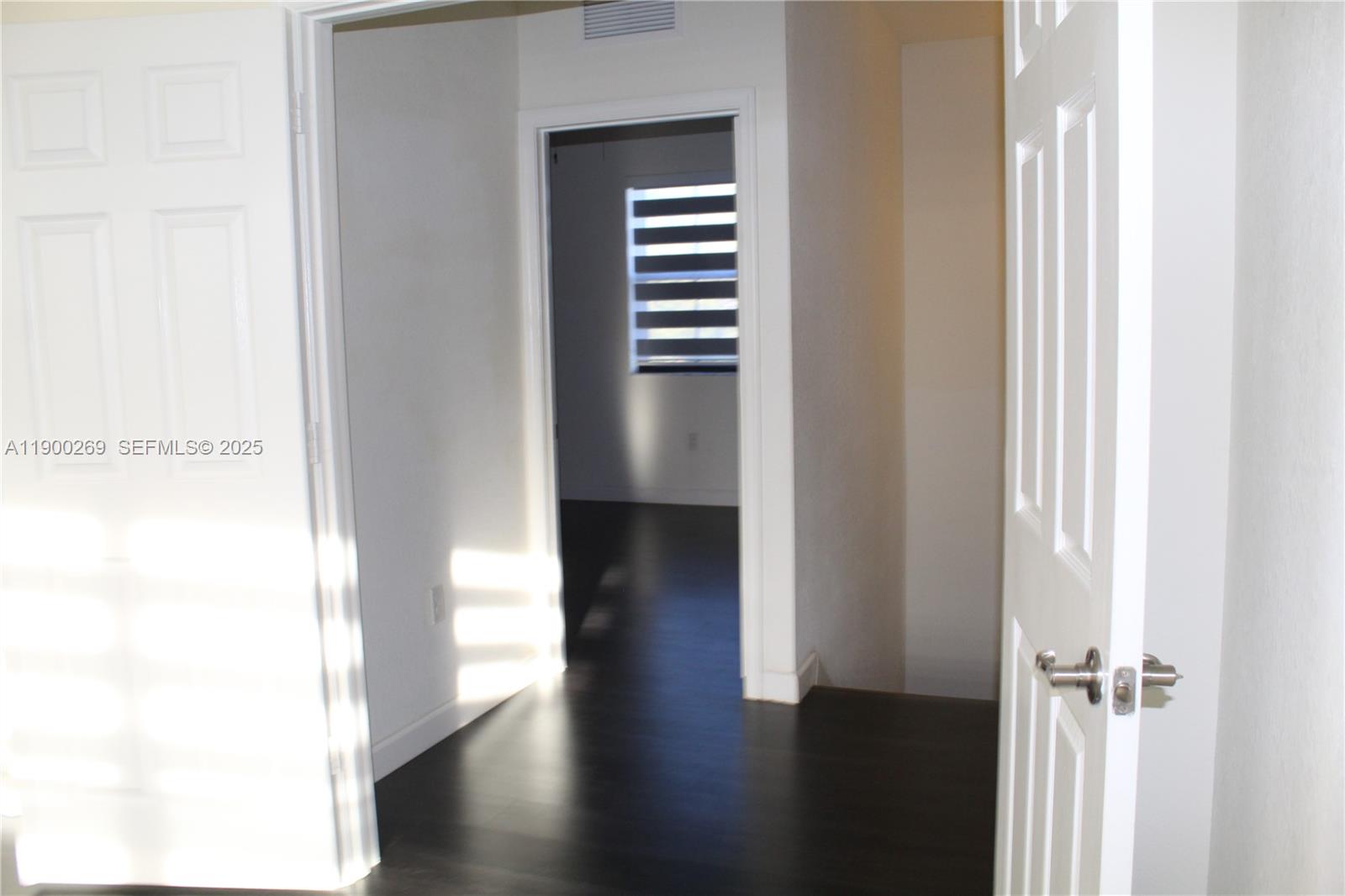 25096 Southwest 118th Avenue, Unit 25096 Homestead, FL 33032 - Photo 52 of 78 a view of a hallway with wooden floor