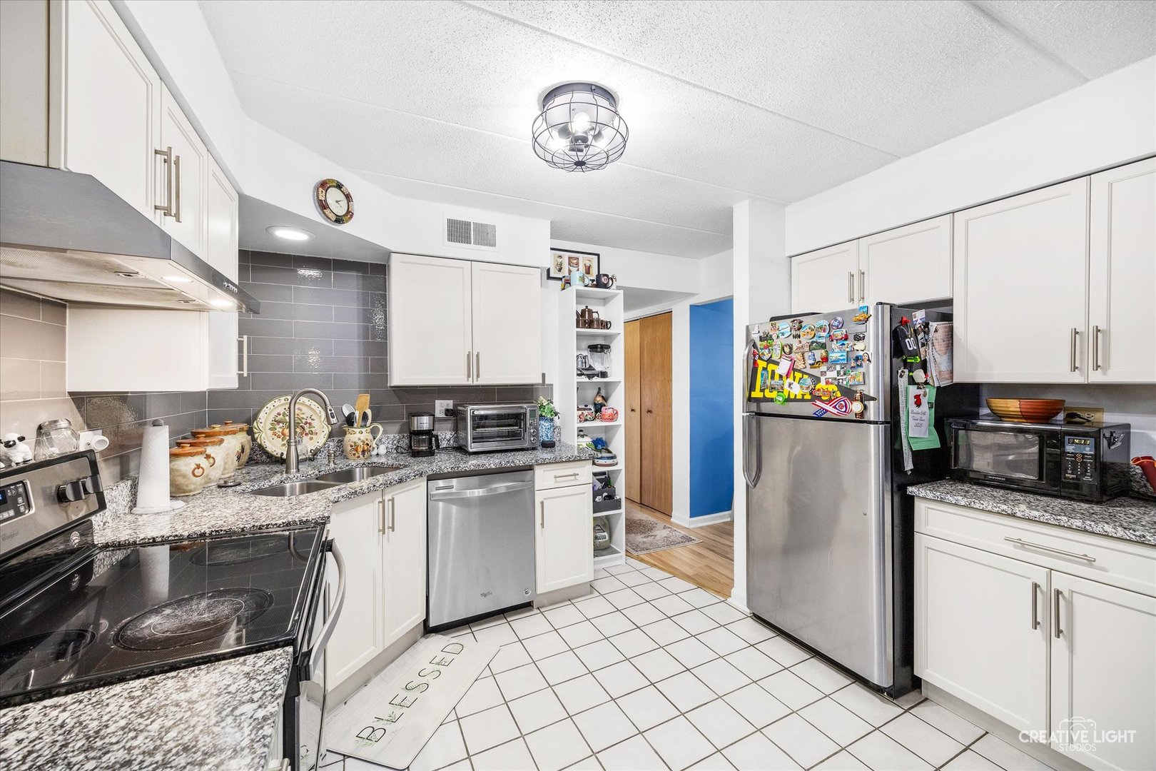 491 Timber Ridge Drive, Unit 102 Carol Stream, IL 60188 - Photo 7 of 18 a kitchen with stainless steel appliances granite countertop a sink stove and refrigerator