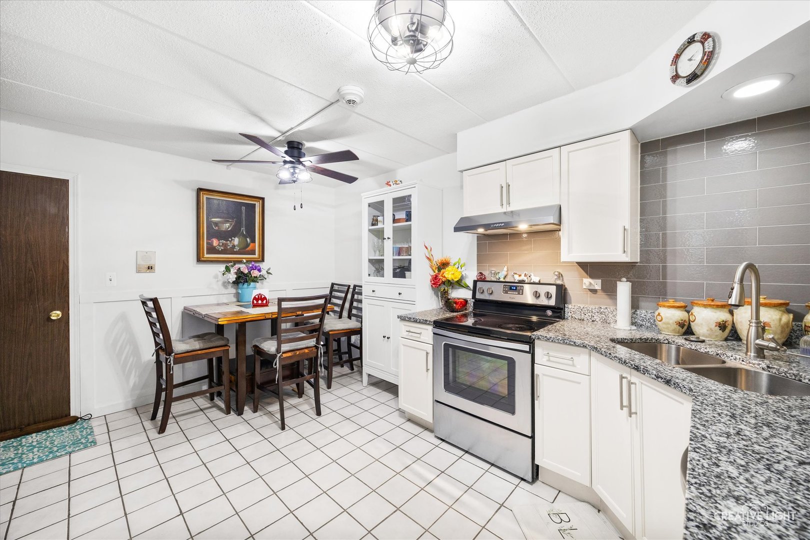 491 Timber Ridge Drive, Unit 102 Carol Stream, IL 60188 - Photo 8 of 18 a kitchen with stainless steel appliances granite countertop a stove a sink dishwasher a dining table and chairs with wooden floor