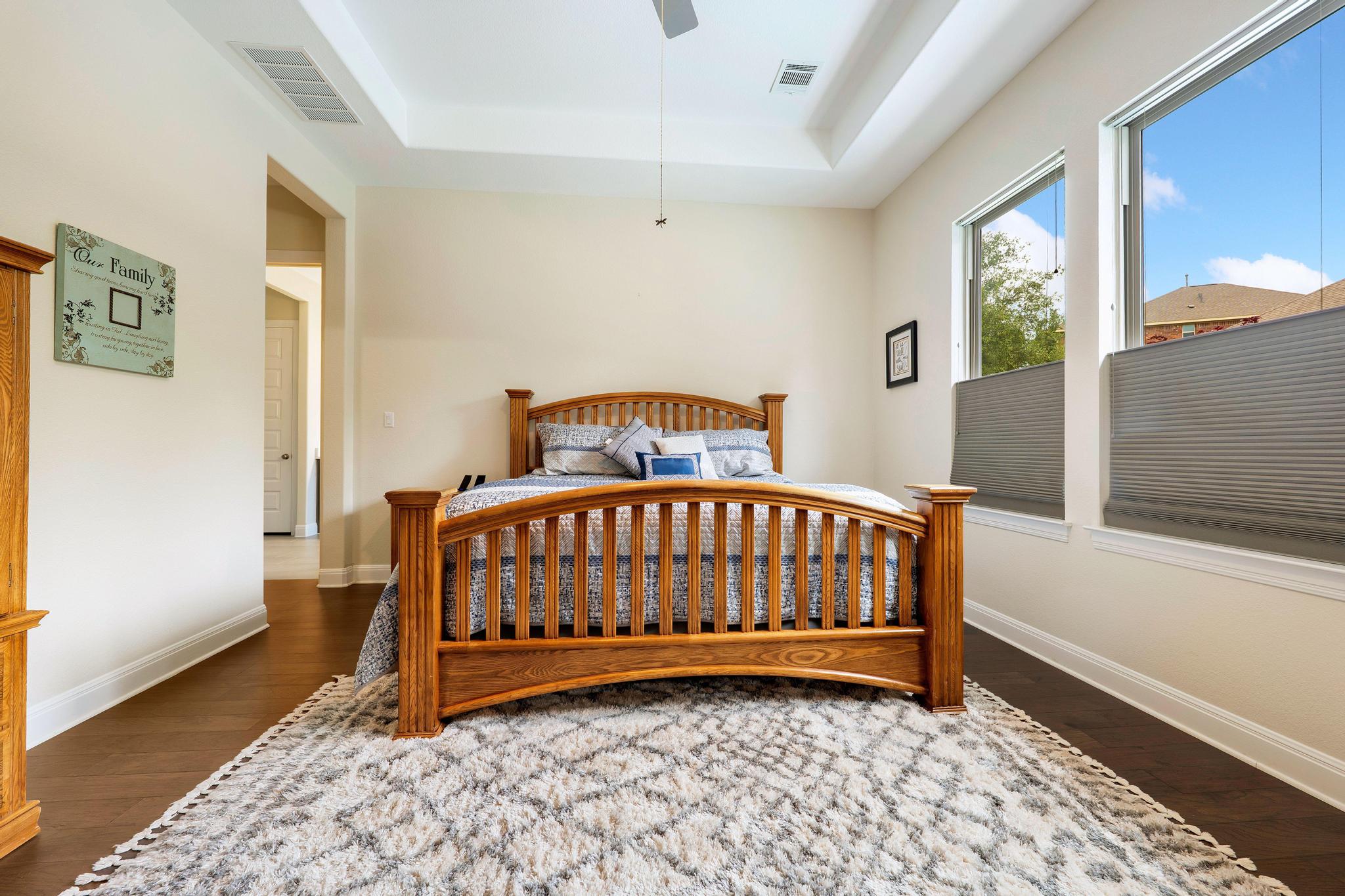 1009 Legacy Crossing Georgetown, TX 78628 - Photo 19 of 40 A tranquil primary bedroom features rich hardwood flooring and a vaulted ceiling.