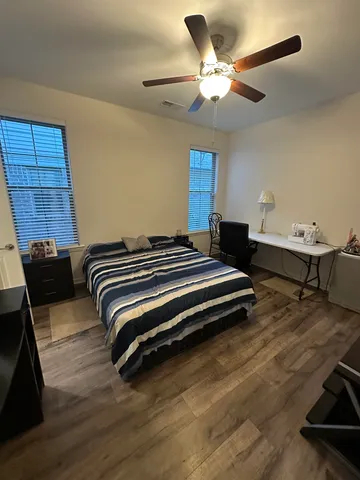 a bedroom with a bed and a ceiling fan