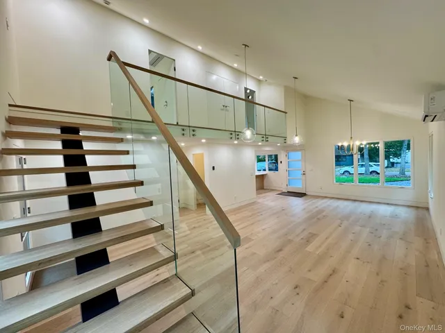 a view of an empty room with wooden floor and a ceiling fan