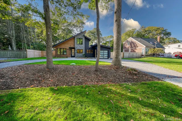 a view of a house with backyard and trees