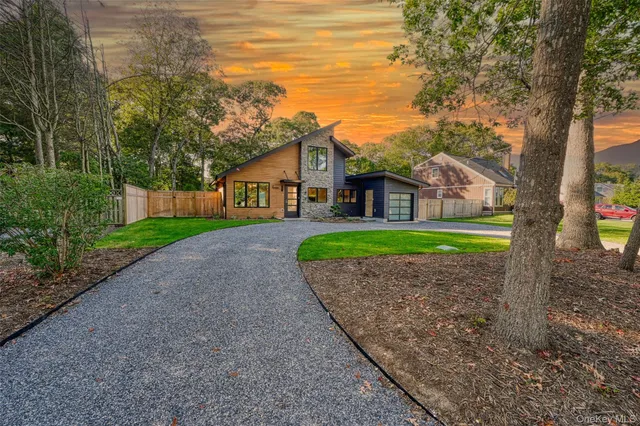 a front view of a house with a garden and yard