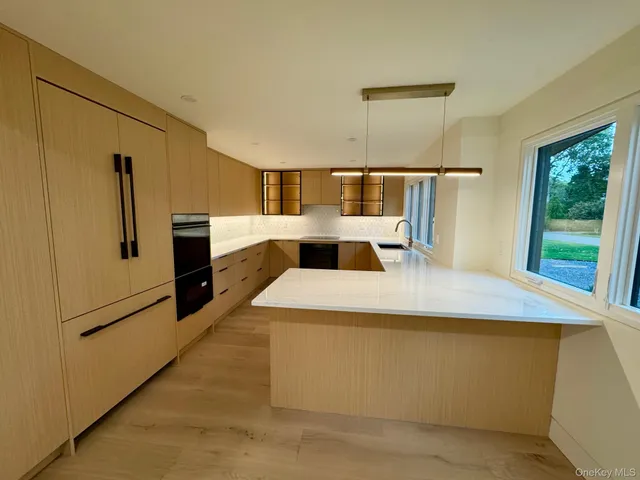 a large kitchen with stainless steel appliances kitchen island a large counter top and a refrigerator