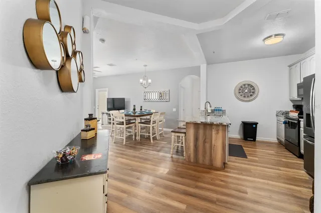 a living room with furniture kitchen view and a wooden floor