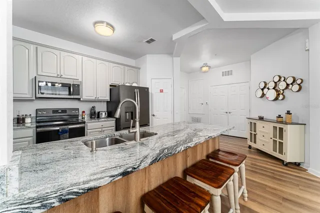 a spacious bathroom with a granite countertop sink and a mirror