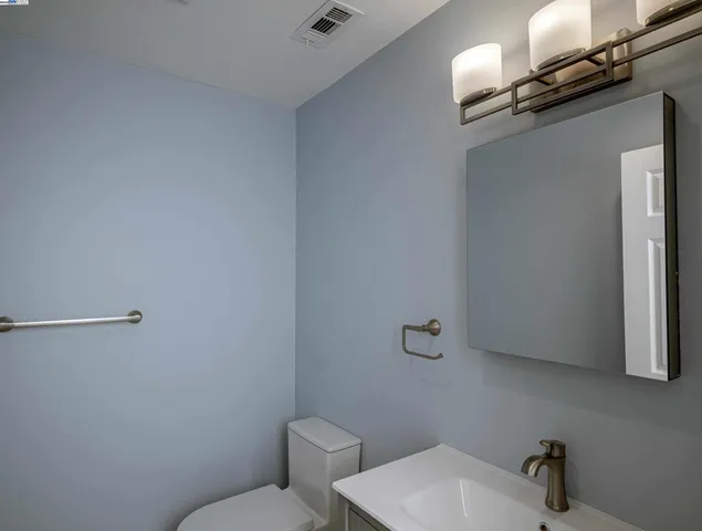 a bathroom with a toilet a sink and mirror