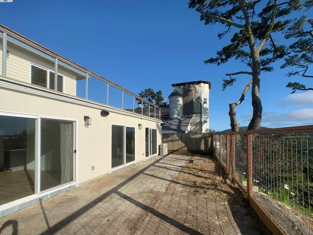 a view of a house with a tree and wooden fence