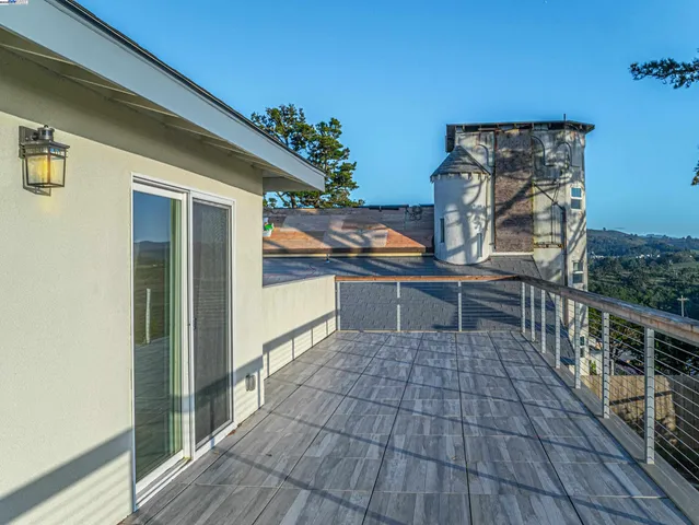 a view of a balcony with wooden floor and iron stairs