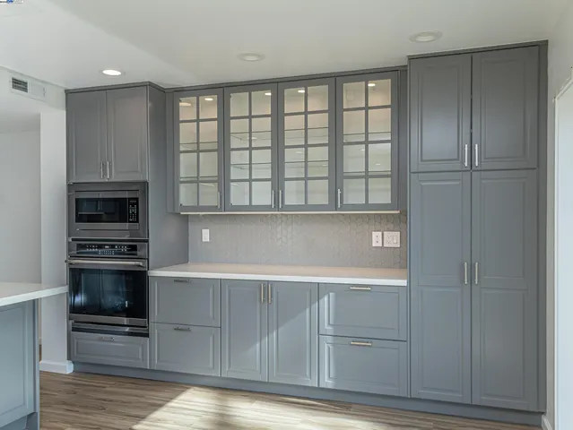 a kitchen with white cabinets and a stove