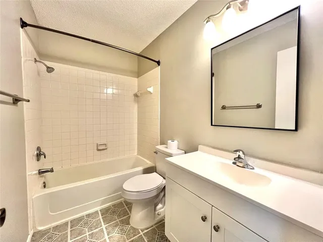 a bathroom with a bathtub shower sink vanity and toilet