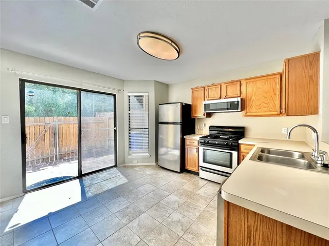 a kitchen with stainless steel appliances granite countertop a refrigerator stove top oven and sink