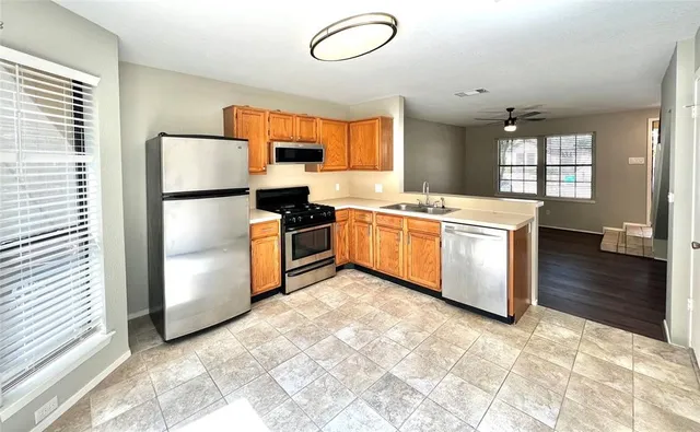 a kitchen with stainless steel appliances granite countertop a stove a sink dishwasher and a refrigerator