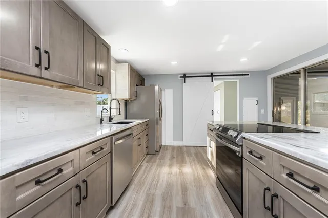 a view of an empty room with wooden floor and windows