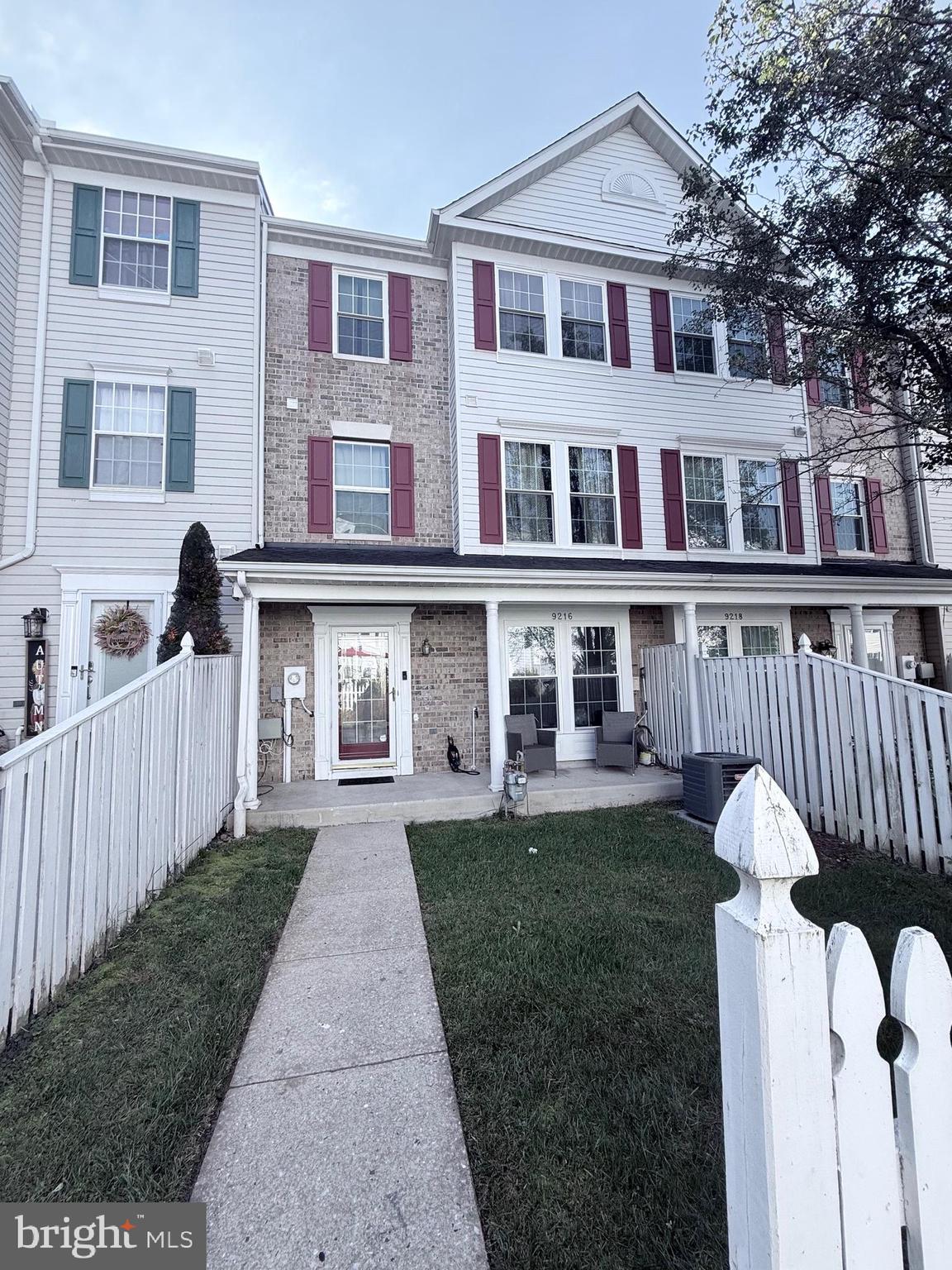 9216 Leigh Choice Court, Unit 10 Owings Mills, MD 21117 - Photo 2 of 32 a front view of a house with a garden and trees