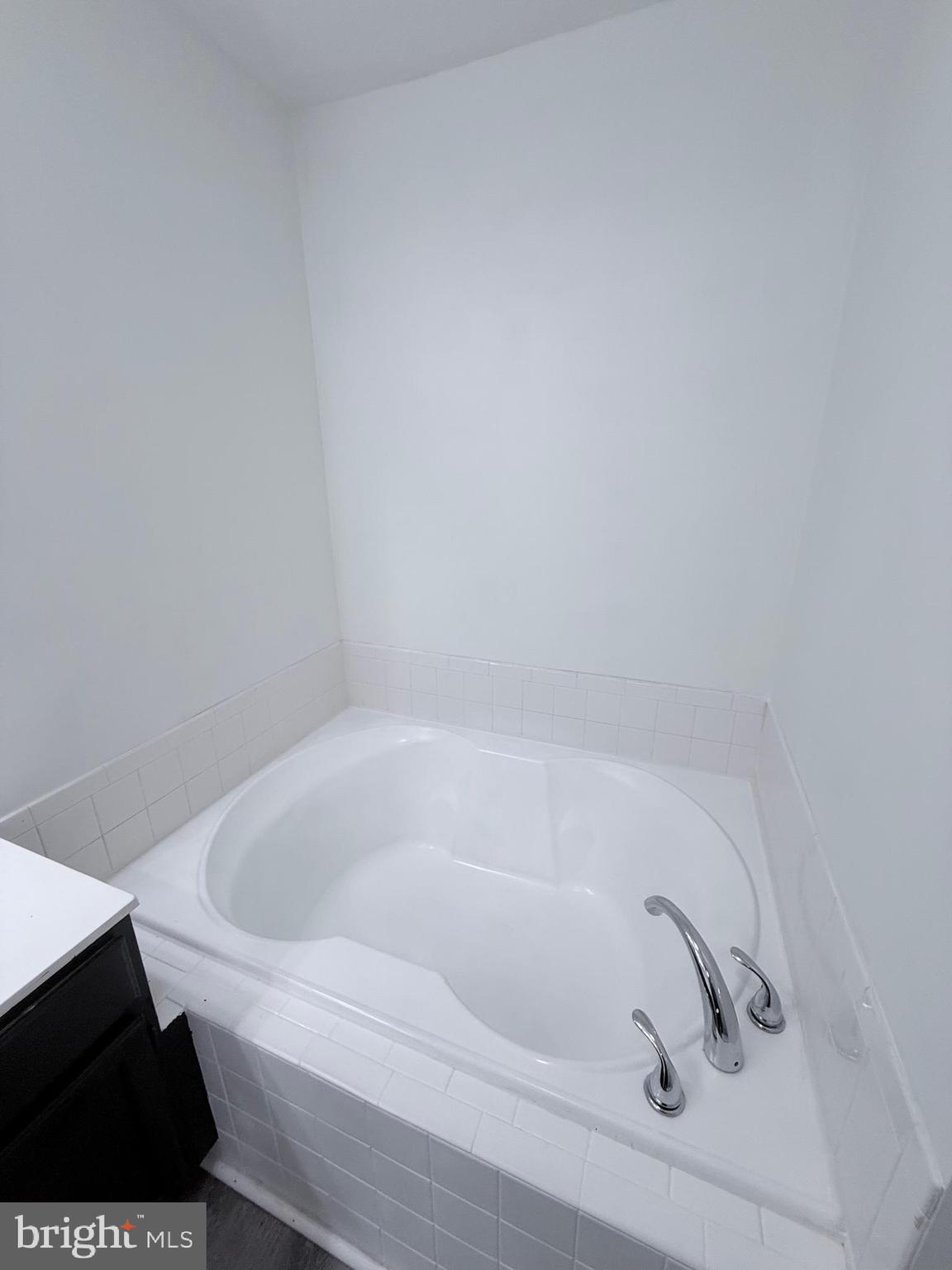 9216 Leigh Choice Court, Unit 10 Owings Mills, MD 21117 - Photo 30 of 32 a white bath tub sitting in a bathroom