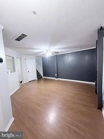 a view of an empty room with wooden floor