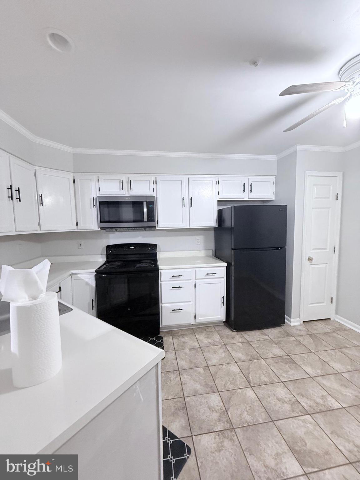 9216 Leigh Choice Court, Unit 10 Owings Mills, MD 21117 - Photo 6 of 32 a kitchen with stainless steel appliances a refrigerator sink and cabinets