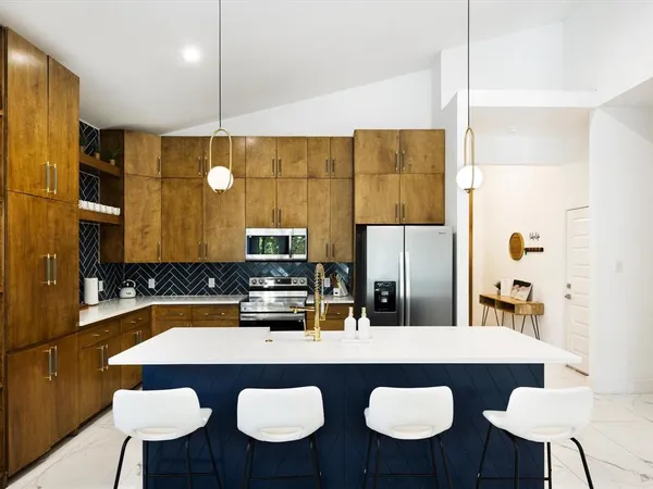 a kitchen with a sink a counter and chairs