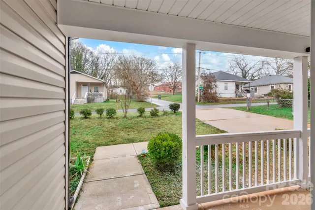 a view of a hallway with wooden floor and a living room