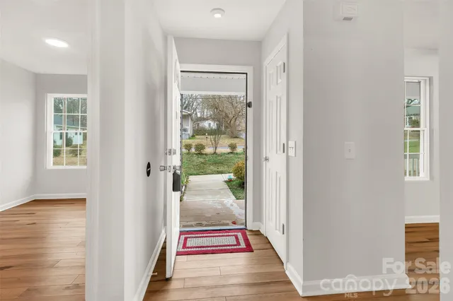 a room with stainless steel appliances kitchen island granite countertop a table chairs and a refrigerator