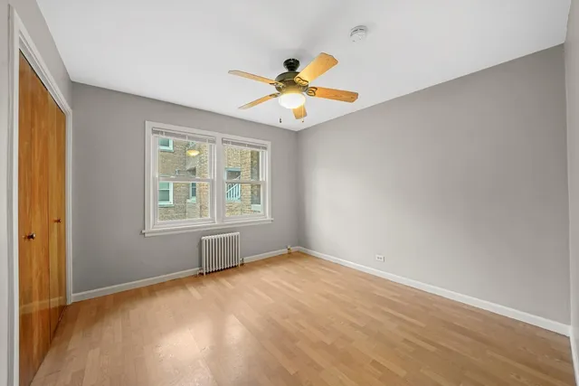 an empty room with a window and a ceiling fan