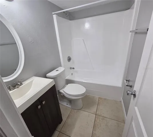 a bathroom with a toilet a sink a mirror and a shower