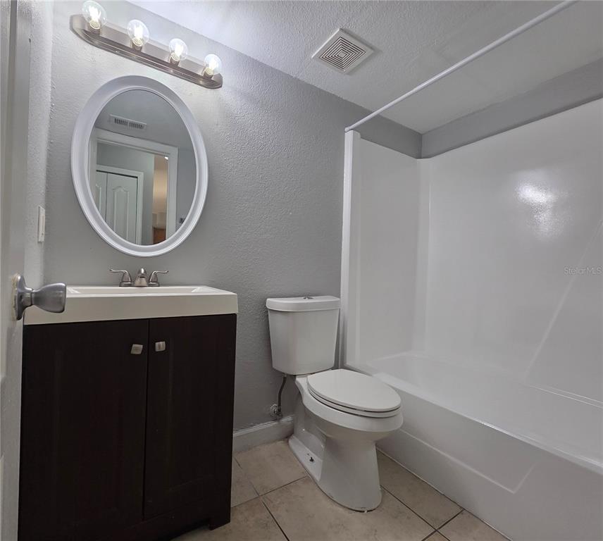 510 Golden Raintree Place, Unit 510 Brandon, FL 33510 - Photo 16 of 18 a bathroom with a toilet a sink a mirror and a shower