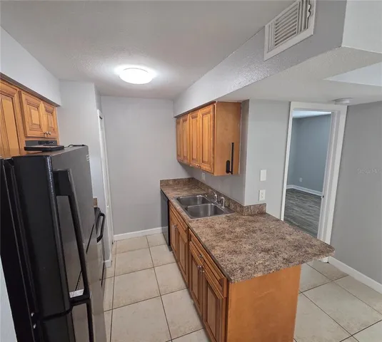 a kitchen with stainless steel appliances granite countertop a refrigerator a stove and a sink