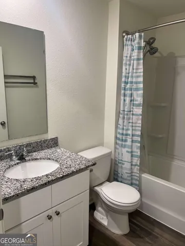 a bathroom with a granite countertop sink toilet and shower