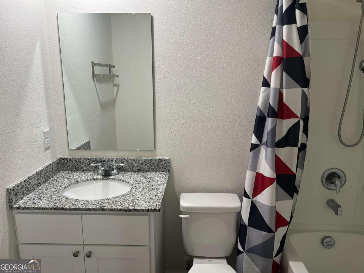 127 Oarsman Crossing St. Marys, GA 31558 - Photo 10 of 17 a bathroom with a granite countertop sink a toilet and shower