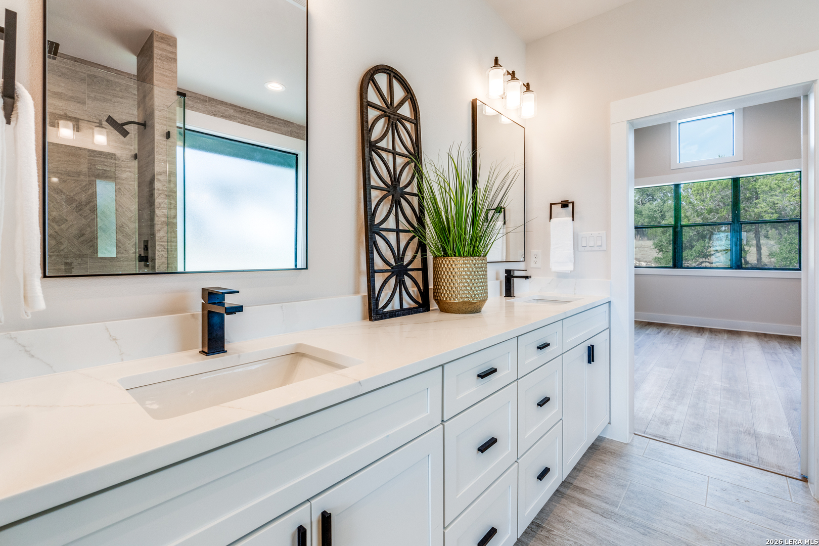 166 Restless Wind Spring Branch, TX 78070 - Photo 11 of 36 a bathroom with a double vanity sink a mirror and next to a window