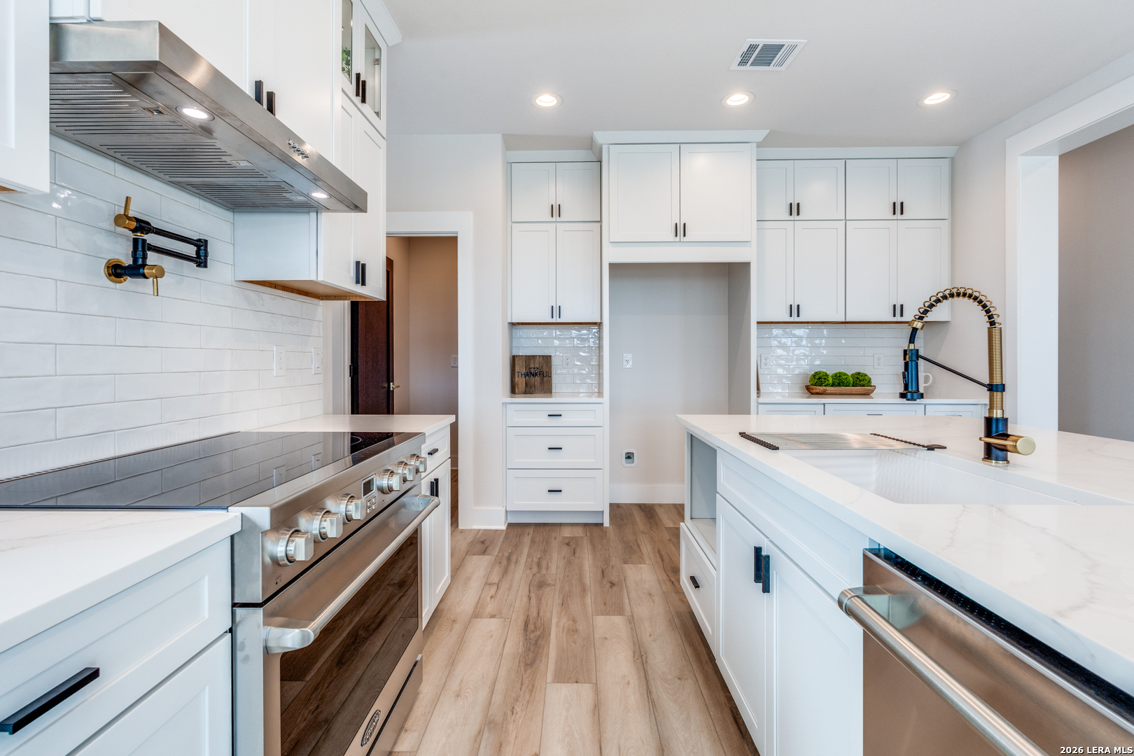166 Restless Wind Spring Branch, TX 78070 - Photo 12 of 36 a kitchen with a stove a sink and a refrigerator