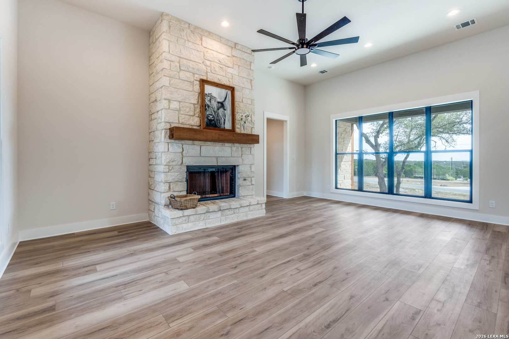 166 Restless Wind Spring Branch, TX 78070 - Photo 5 of 36 a view of an empty room with wooden floor fireplace and a window