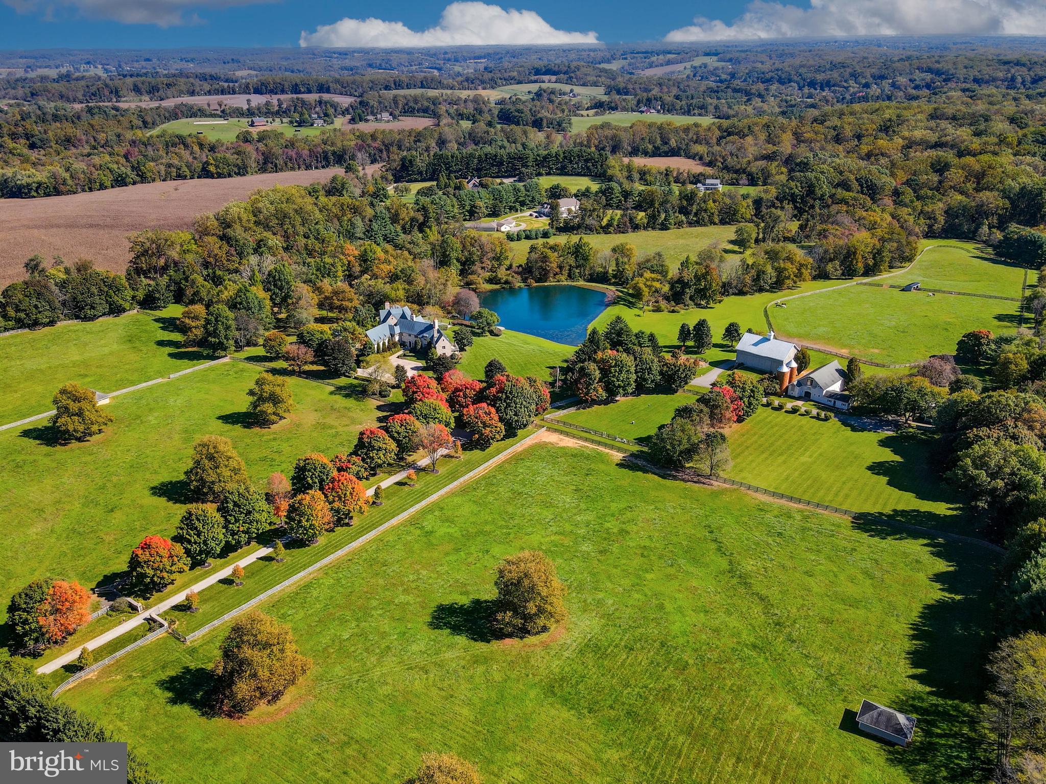 an aerial view of a houses with a lake and trees