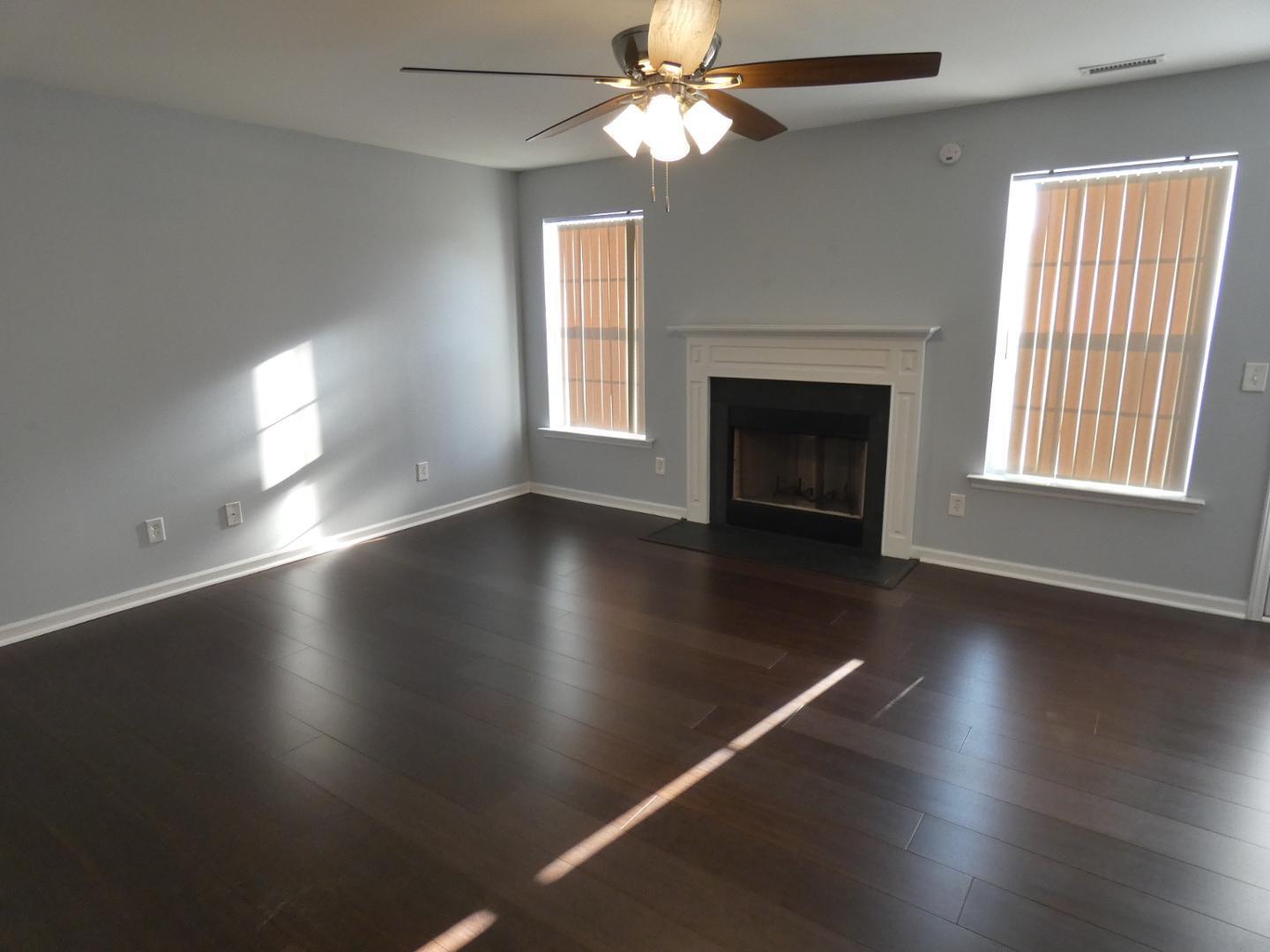 1624 Brown Owl Drive Raleigh, NC 27610 - Photo 6 of 22 an empty room with wooden floor fireplace and windows