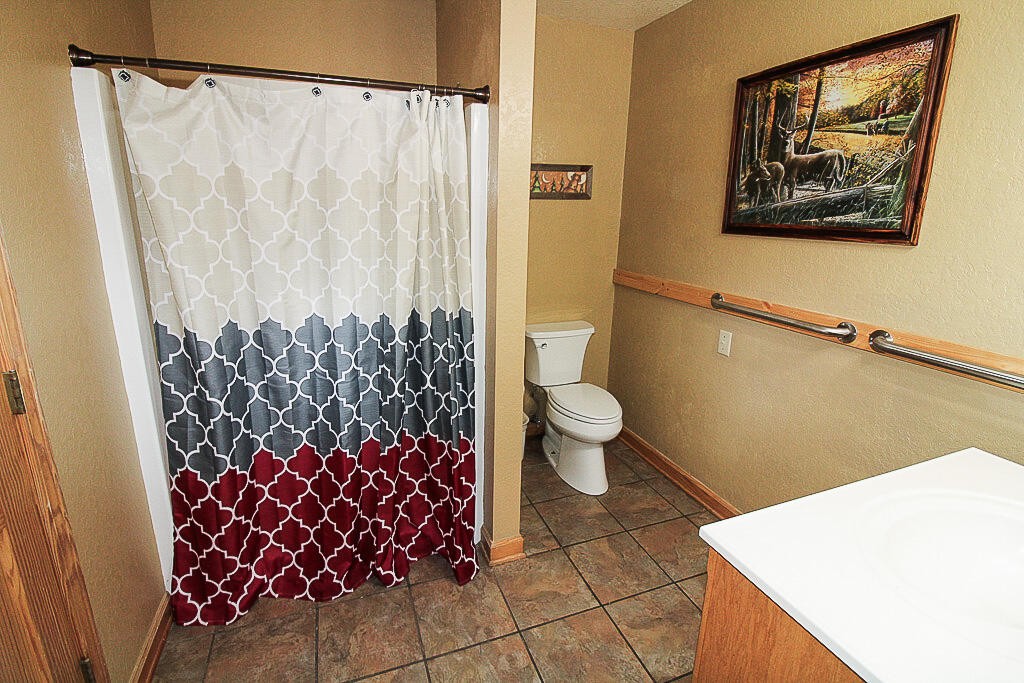443 Loop Road Gatlinburg, TN 37738 - Photo 34 of 40 a bath room with a toilet and a shower curtain