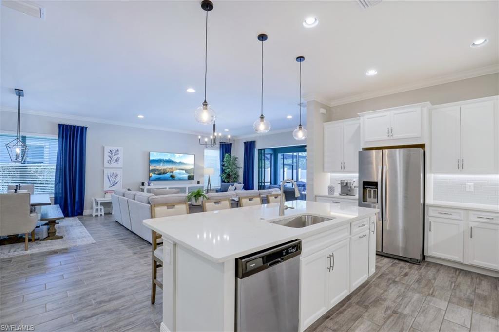 3528 Pilot Circle Naples, FL 34120 - Photo 17 of 46 a kitchen with refrigerator a sink and chairs