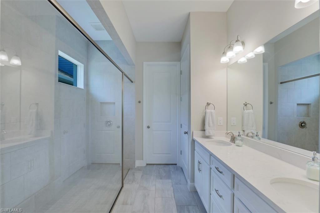 3528 Pilot Circle Naples, FL 34120 - Photo 21 of 46 a bathroom with a double vanity sink and a mirror