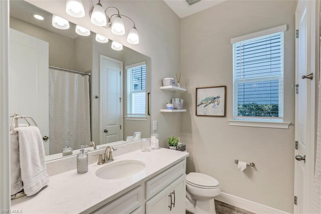 3528 Pilot Circle Naples, FL 34120 - Photo 28 of 46 a bathroom with a sink a toilet and a mirror